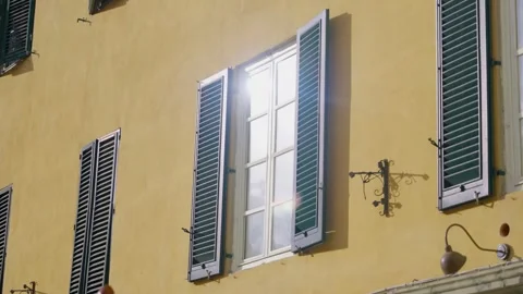 Sunlight reflects from glass window in old historic looking building in Europe Stock Footage 308668845