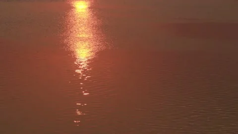 The sunlight reflects from the water, making a red yellow shiny pattern on th Stock Footage 140837206