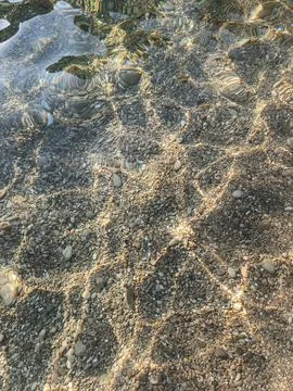 Sunlight refraction grid on sea floor in Cap d'Ail shallows 库存照片