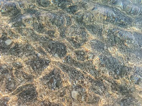 Sunlight refraction patterns on clear sea floor at Cap d'Ail beach Stock Photos