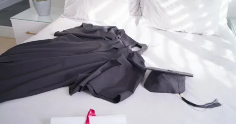 Sunlight is shifting as sun moves, casting bands across black graduation gown, Stock Footage 341027333