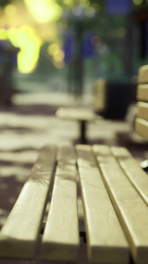 Sunlight shines on empty park benches in a vibrant community space Vídeos de archivo 327380096