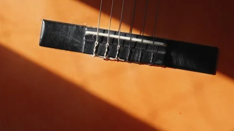 Sunlight shines on guitar strings as window blinds open Видео 316558738