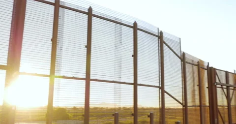 Sunlight Shines Through the Bars of the Wall Dividing Mexico and America Stock Footage 67654269