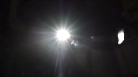 Sunlight shines through opening and creates lens flare as camera tilts up Stock Footage 257776277