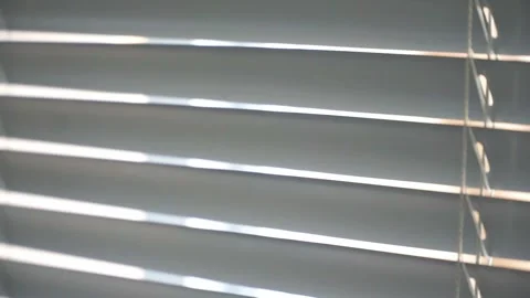 Sunlight shines through partially closed blinds, creating elegant linear Stock Footage 338192044