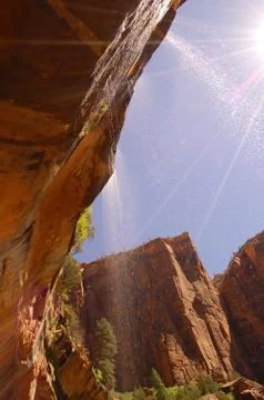 Sunlight shines through a small waterfall Stock Photos