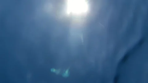 Sunlight shines through the water surface above blue waves with bright reflectio Stock Footage 339280028