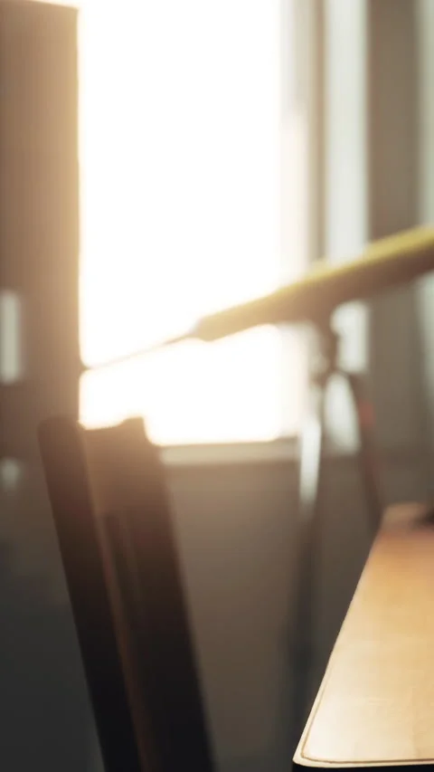 Sunlight shines through a window illuminating a chair and table in the room Stock Footage 341243369