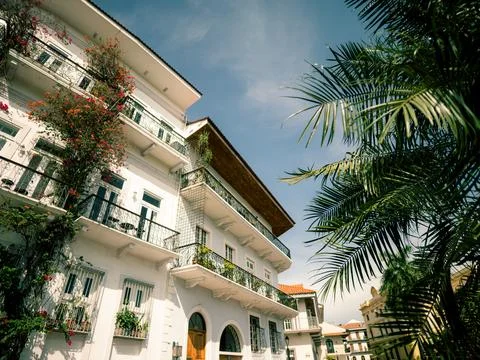 Sunlight shines on a white building with multiple balconies Foto stock