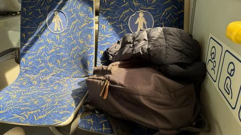 Sunlight shining on blue patterned priority seats in a train or bus with a Stock Photos