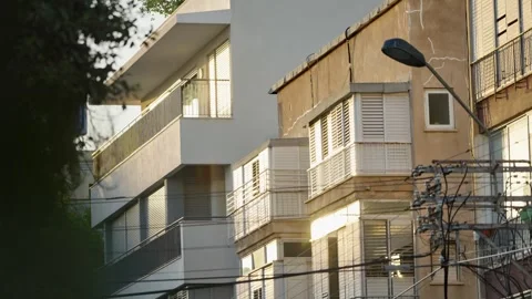Sunlight shining on building balconies in small local street in Tel Aviv Israel Stock Footage 312446751