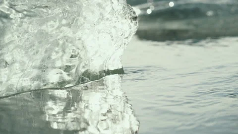Sunlight shining through clear glacier ice in water close up Video stock 348027295