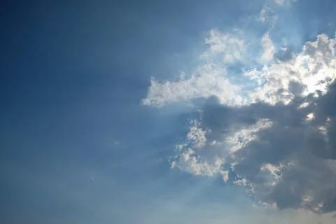 Sunlight shining through the clouds in the blue sky Stock Photos