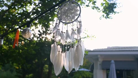 Sunlight shining through a delicate dreamcatcher with white feathers, hanging Stock Footage 285173404