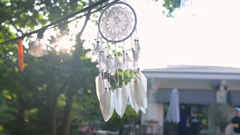 Sunlight shining through a delicate dreamcatcher with white feathers, hanging Stock Footage 285174076
