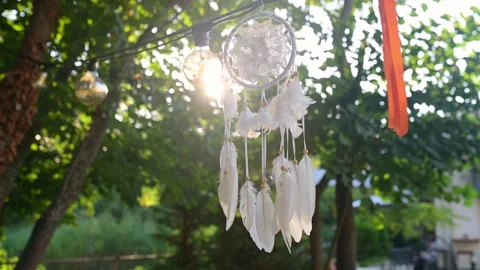 Sunlight shining through a delicate dreamcatcher with white feathers, hanging Stock Footage 285176146