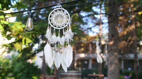 Sunlight shining through a delicate dreamcatcher with white feathers, hanging Stock Footage 285176919