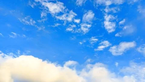 Sunlight shining through puffy clouds. Clouds against a beautiful blue sky Stock Photos