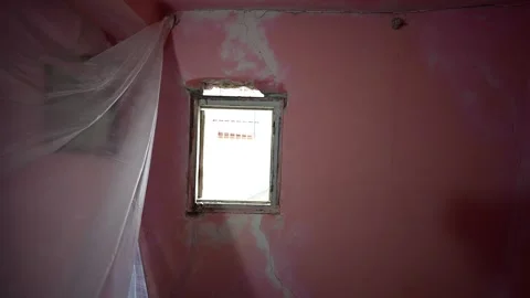 Sunlight shining through window in abandoned room with pink cracked walls Stock Footage 347640715