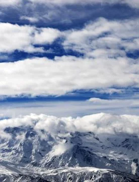 Sunlight snowy mountains in clouds Stock Photos