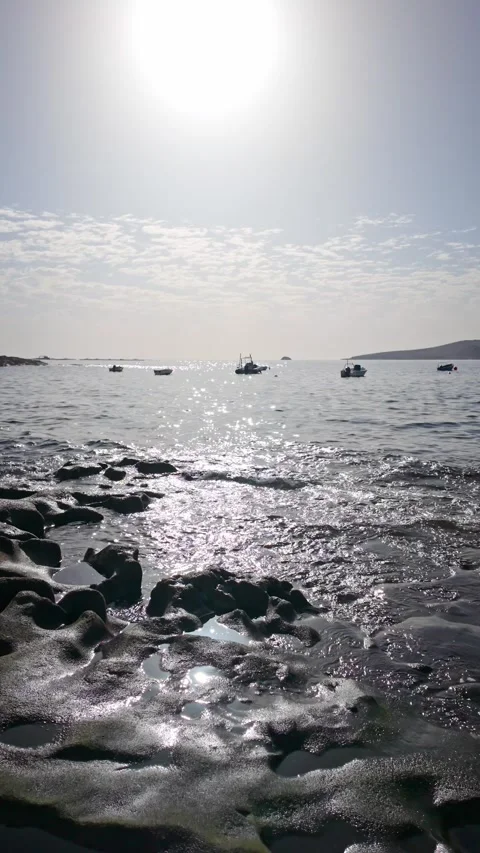 Sunlight sparkling on the water's surface with distant boats in the backgroun Stock Footage 294278422