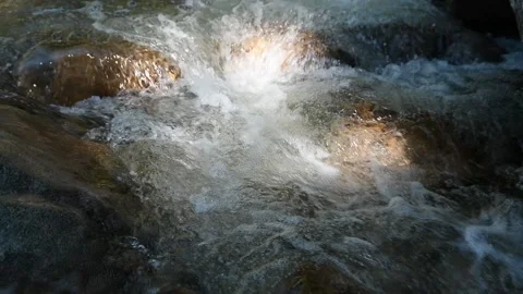 A sunlight spot on the water of a mountain stream (slow motion) Video stock 219388877