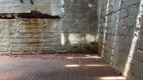 Sunlight Streaming Across Empty Industrial Brick Room with Metal Floor Stock Footage 336804314