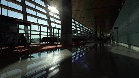 Sunlight streaming into the empty airport terminal, glide back camera motion Video stock 329627112