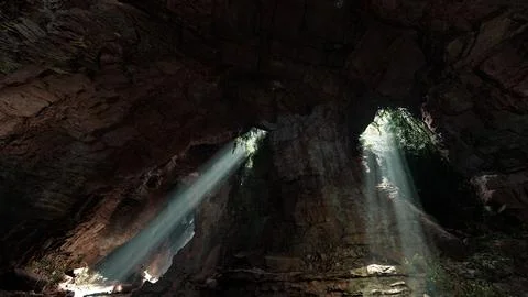 Sunlight streaming through a cave, creating a mesmerizing volume of light 스톡 일러스트