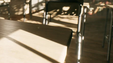 Sunlight Streaming Through a Classroom, Casting Patterns on Empty Desks Video stock 347039743