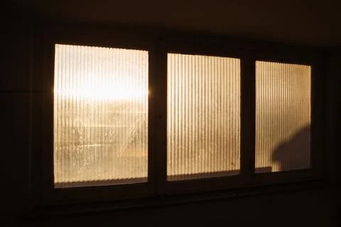 Sunlight Streaming Through Frosted Window Glass at Dawn in apartment building Foto stock