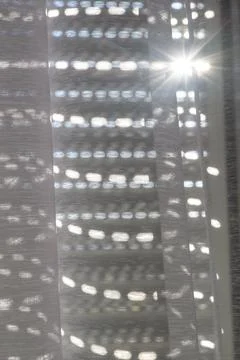 Sunlight streaming through sheer curtains creating a bright, dappled light .. Фото