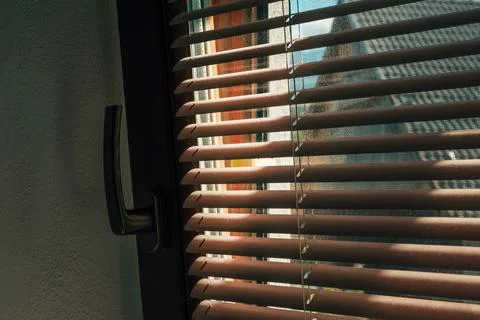 Sunlight streaming through window blinds, casting striped shadow pattern in.. Stock Photos