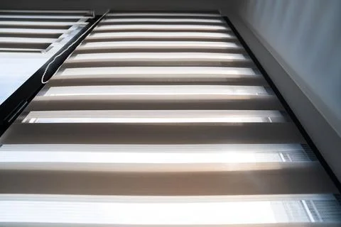 Sunlight streaming through zebra roller blinds in bright modern apartment Foto stock