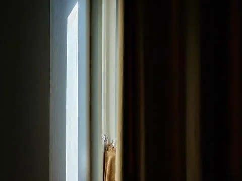 Sunlight streams through the curtains and windows in the bedroom. Foto stock
