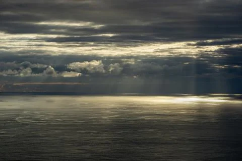 Sunlight streams through dark clouds over the Atlantic Ocean near the Azores Stock Photos