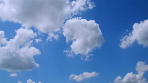 Sunlight streams through fluffy clouds in a blue sky in spring. 4k60p Stock Footage 132221217