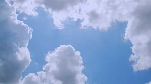 Sunlight streams through large fluffy clouds in a blue sky in spring. 4k60p Stock Footage 132221007