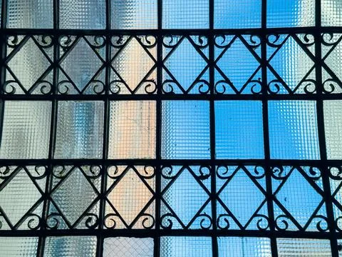 Sunlight streams through a patterned glass window in an urban building duri.. Stock Photos