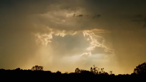 Sunlight streams through rain and dark clouds in spring. 4k60p Stock Footage 132223412