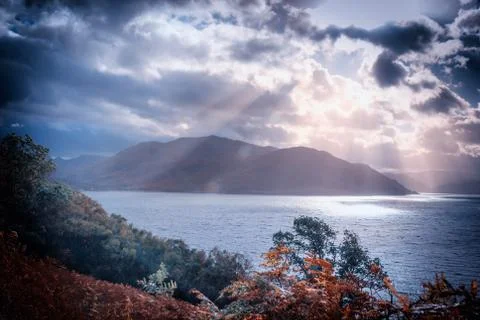 Sunlight through clouds illuminates a Scottish Loch Stock Photos