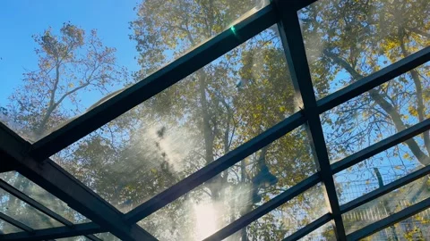 Sunlight through glass canopy over metro entrance with sun lens flare Stock Footage 346542736