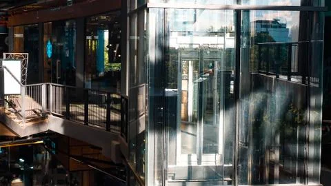Sunlight through Glass elevator with no people in shopping mall Stock Photos