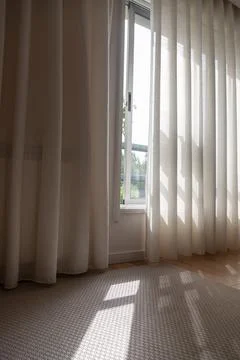 Sunlight through half-open curtains in an interior room Stock Photos