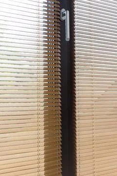 Sunlight Through Partially Opened Window Blinds with Handle Stock Photos