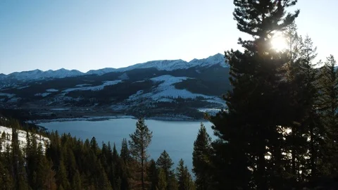 Sunlight through Pine Tree by Mountain Lake Stock Footage 119832586