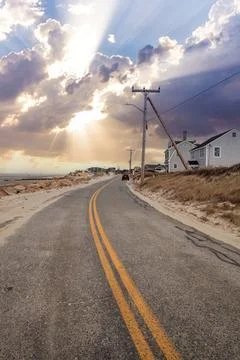 Sunlight through the storm clouds over roadway along Chapin Beach Foto stock