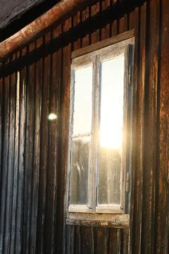 Sunlight through vintage window of rustic wooden cottage Stock Photos