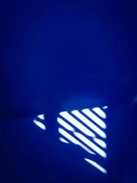 Sunlight window overlay reflection on blue wall separated by line Stock Photos